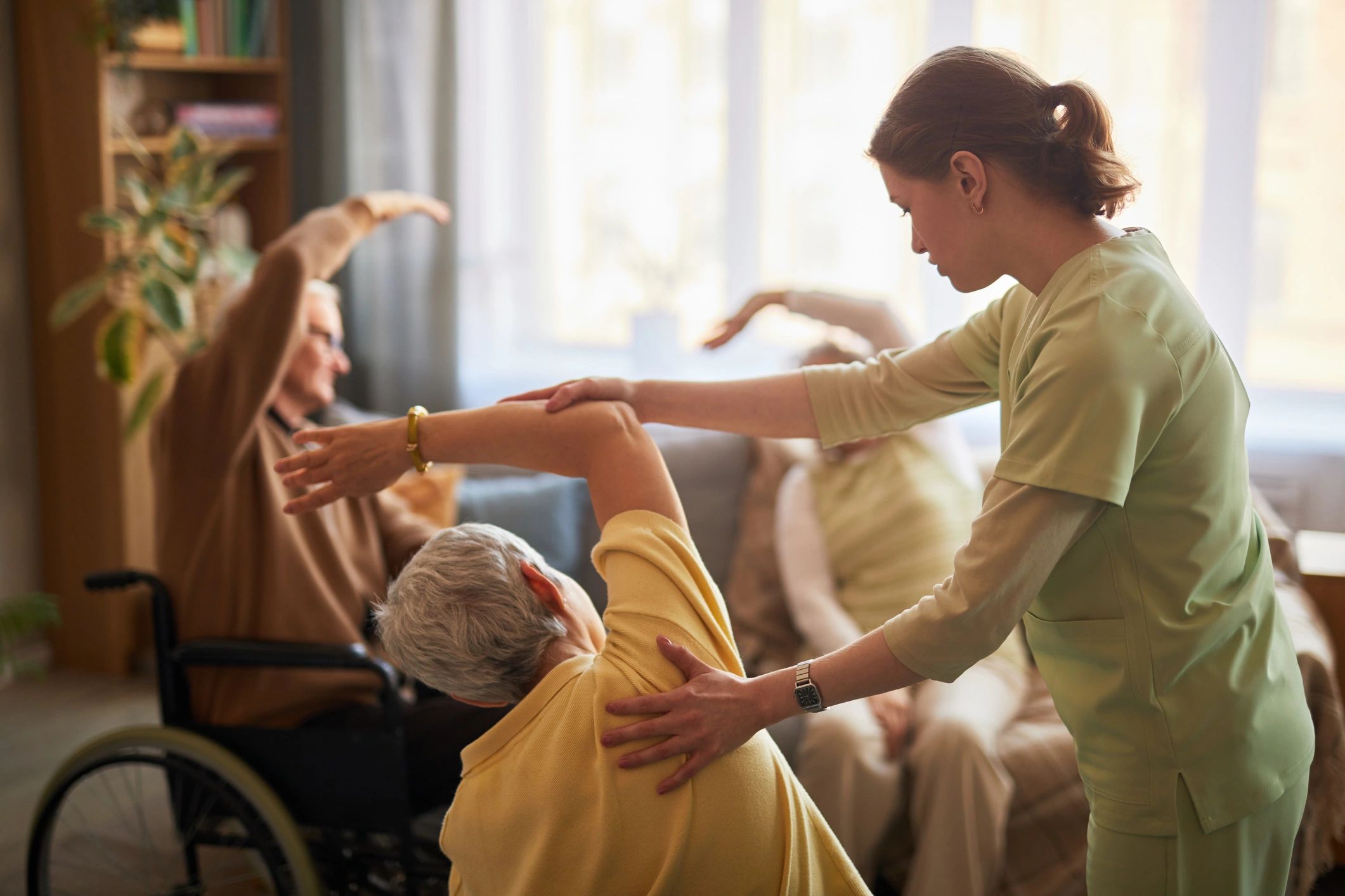 Senior women exercising with caregiver during therapy